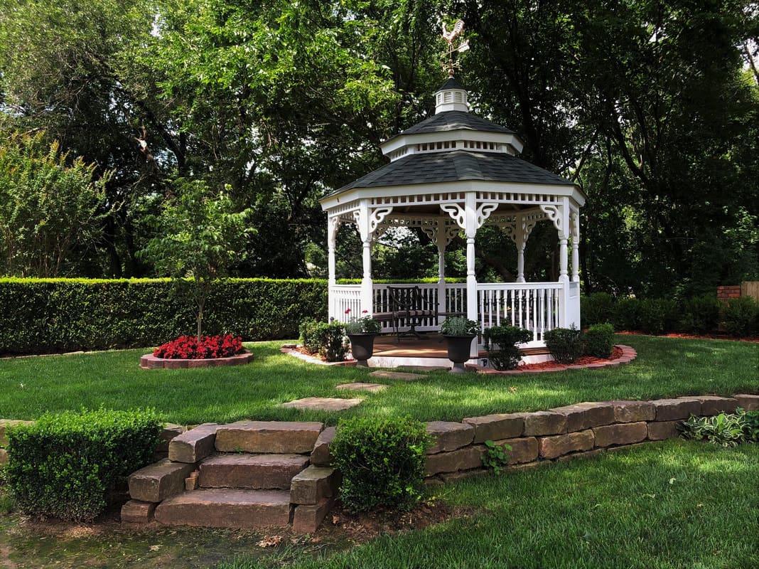 A gazebo in the middle of a garden.
