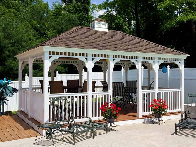 A white gazebo with chairs and tables in the middle.