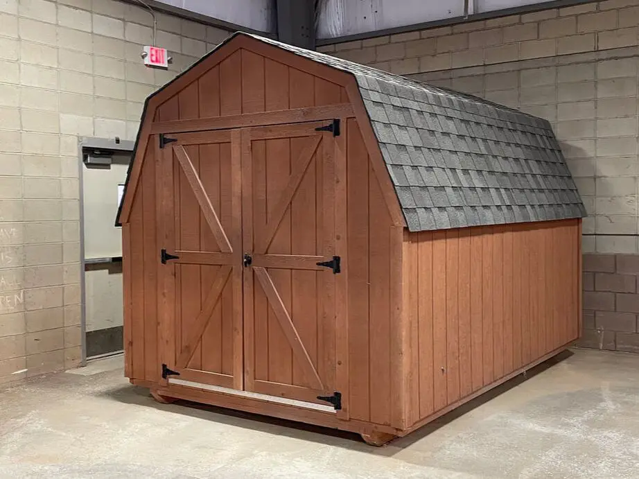 A wooden shed with a metal roof and two doors.