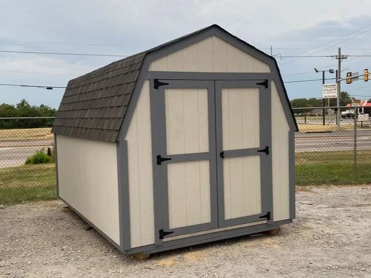 A small shed sitting on top of a gravel road.