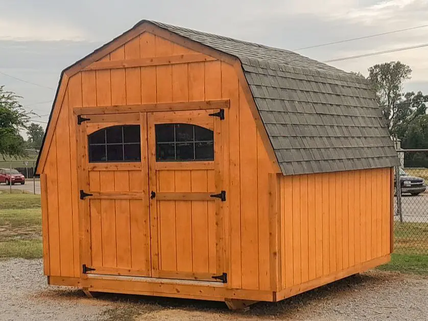 A wooden shed with two windows and a door.