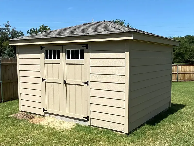 A shed with two doors and windows on the side.