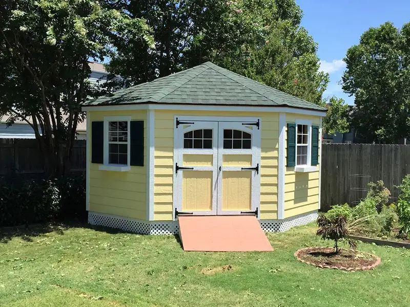 A yellow shed with two doors and a ramp.