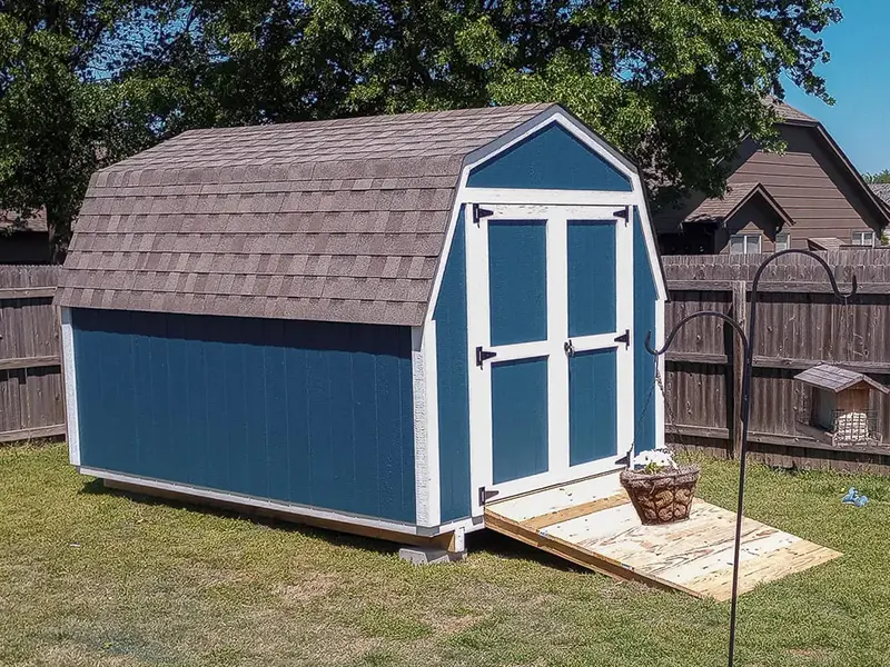 A blue shed with brown roof and white trim.