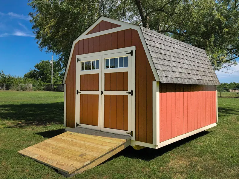 A red and white shed with a ramp going up the side.