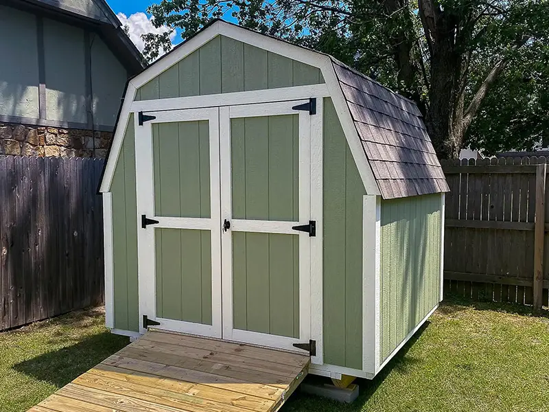 A green shed with a ramp in the middle of it.