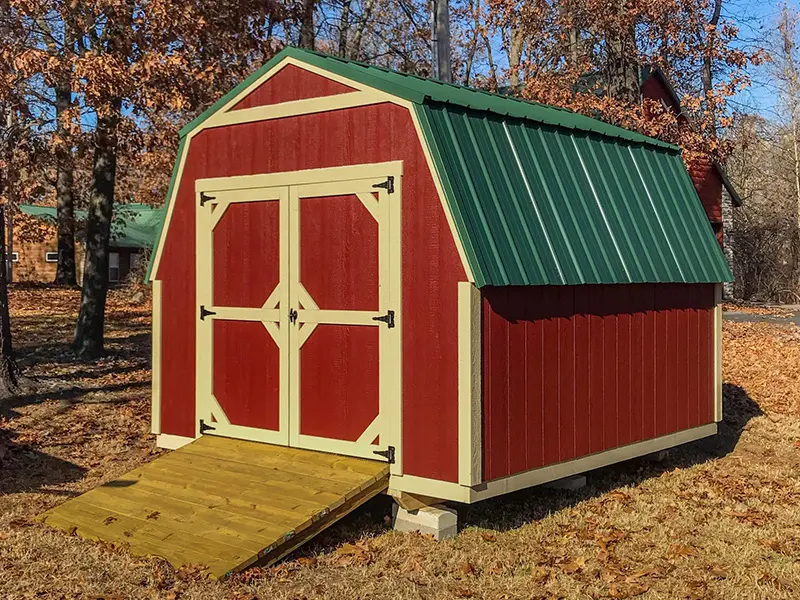A red and yellow shed with a ramp in the front.