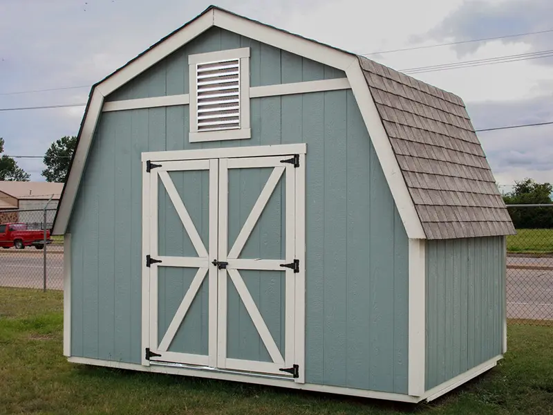 A blue shed with white trim and shutters.