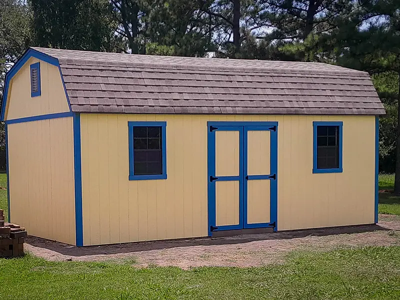 A yellow shed with blue trim and windows.