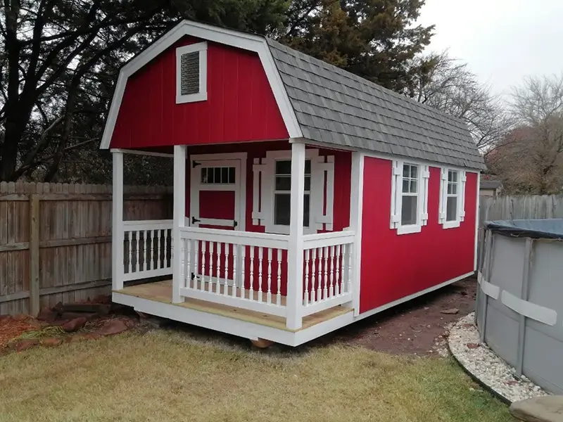 A red and white shed with a porch.