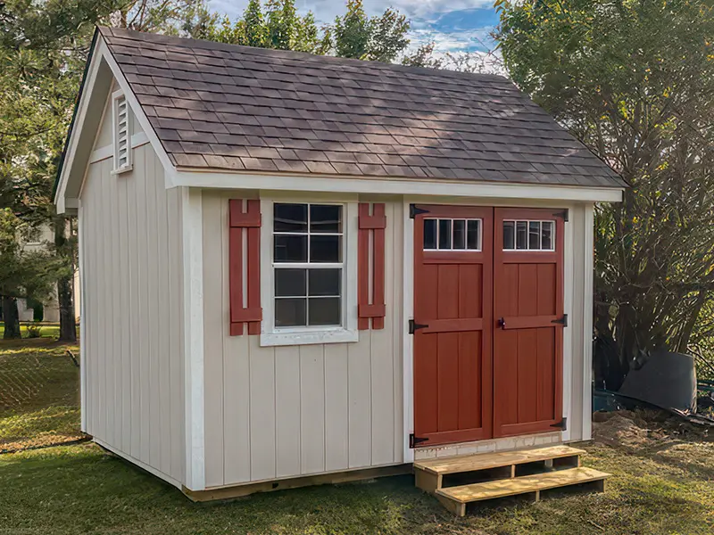 A small shed with red doors and windows.