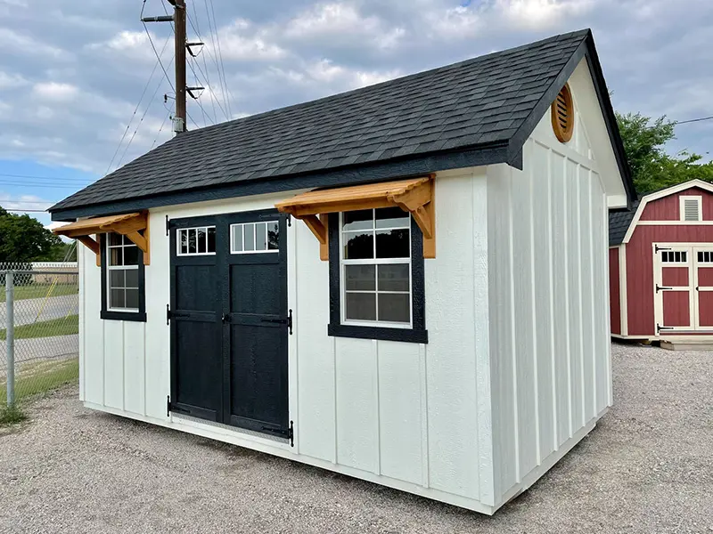 A white shed with black trim and windows.