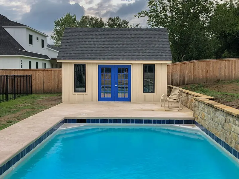 A pool house with blue doors and a white wall.