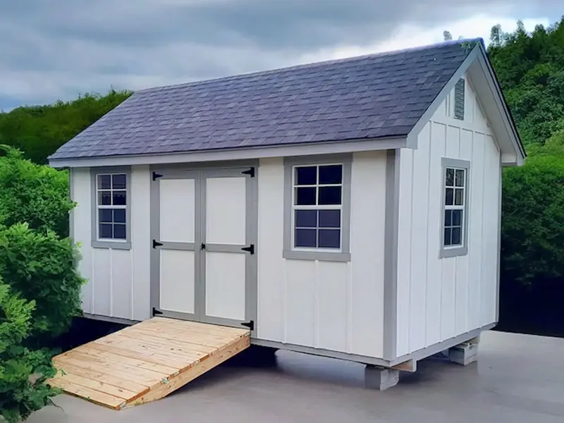 A white shed with a ramp on the side.