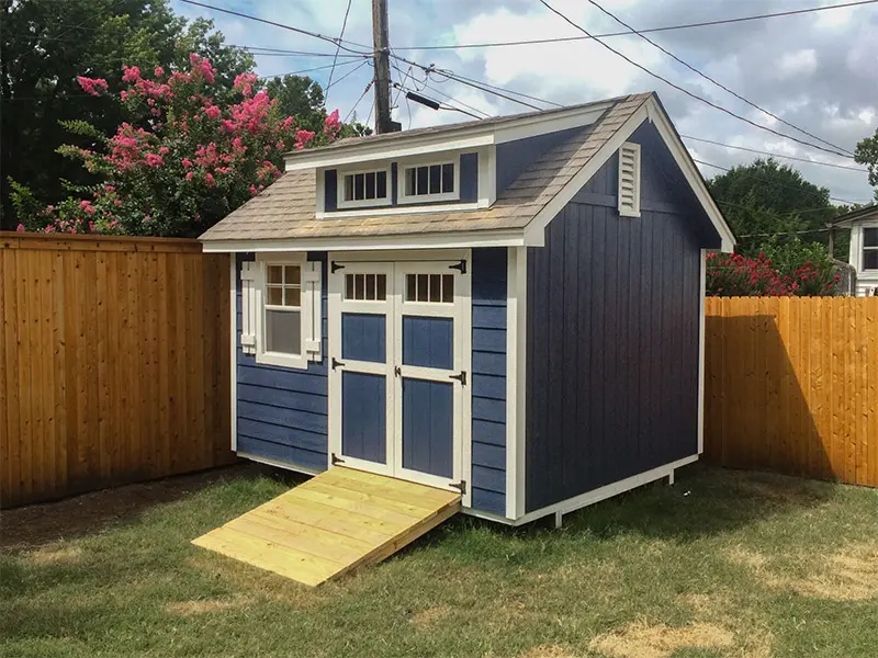 A blue shed with a ramp in the front of it.