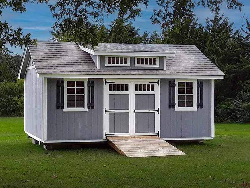 A gray shed with two doors and a ramp.